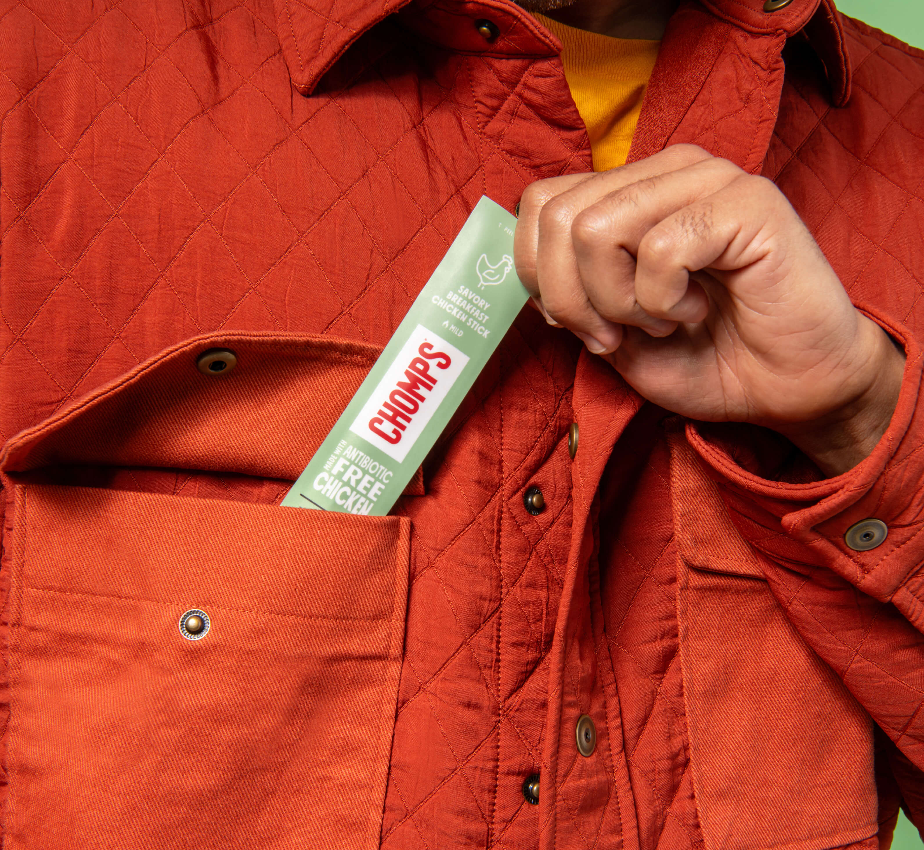 Person wearing a red jacket with a Chomps stick in the pocket