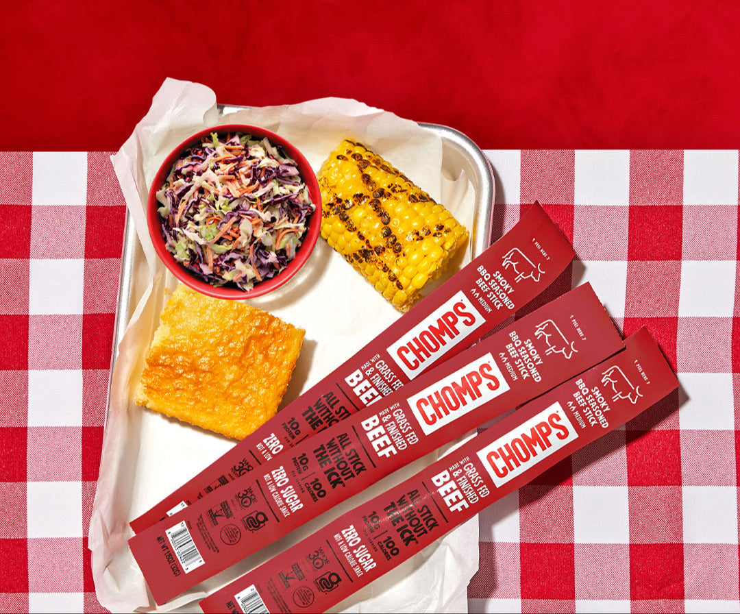 Smoky BBQ Chomps is back! An image of Smoky BBQ Chomps on a picnic table with corn and coleslaw.