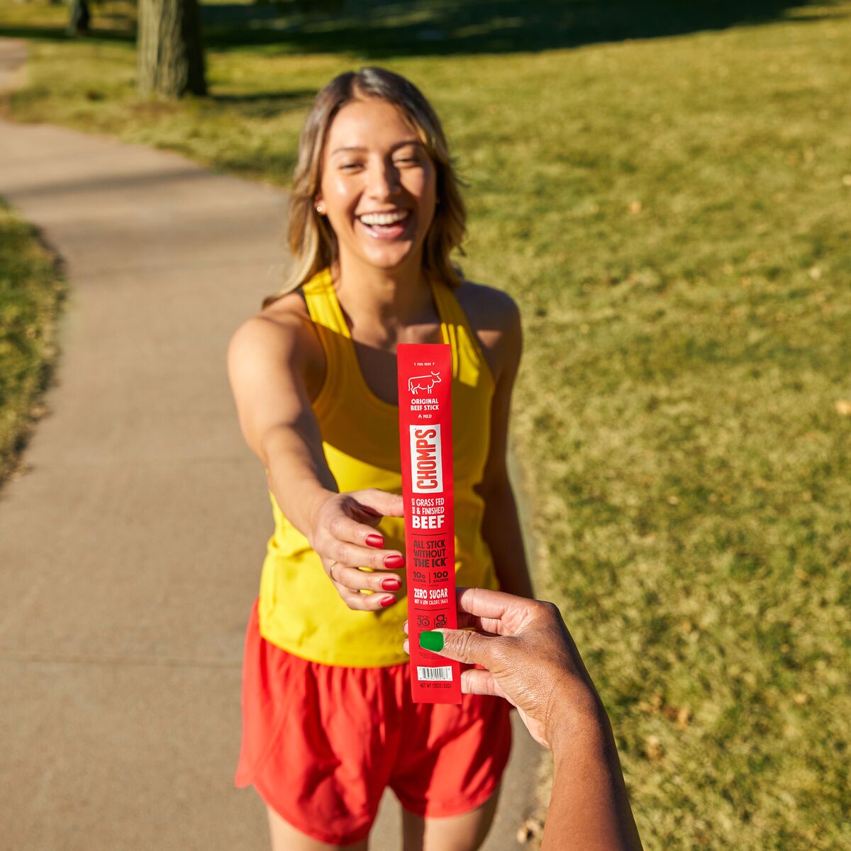 A female runner reaching for a Chomps meat stick