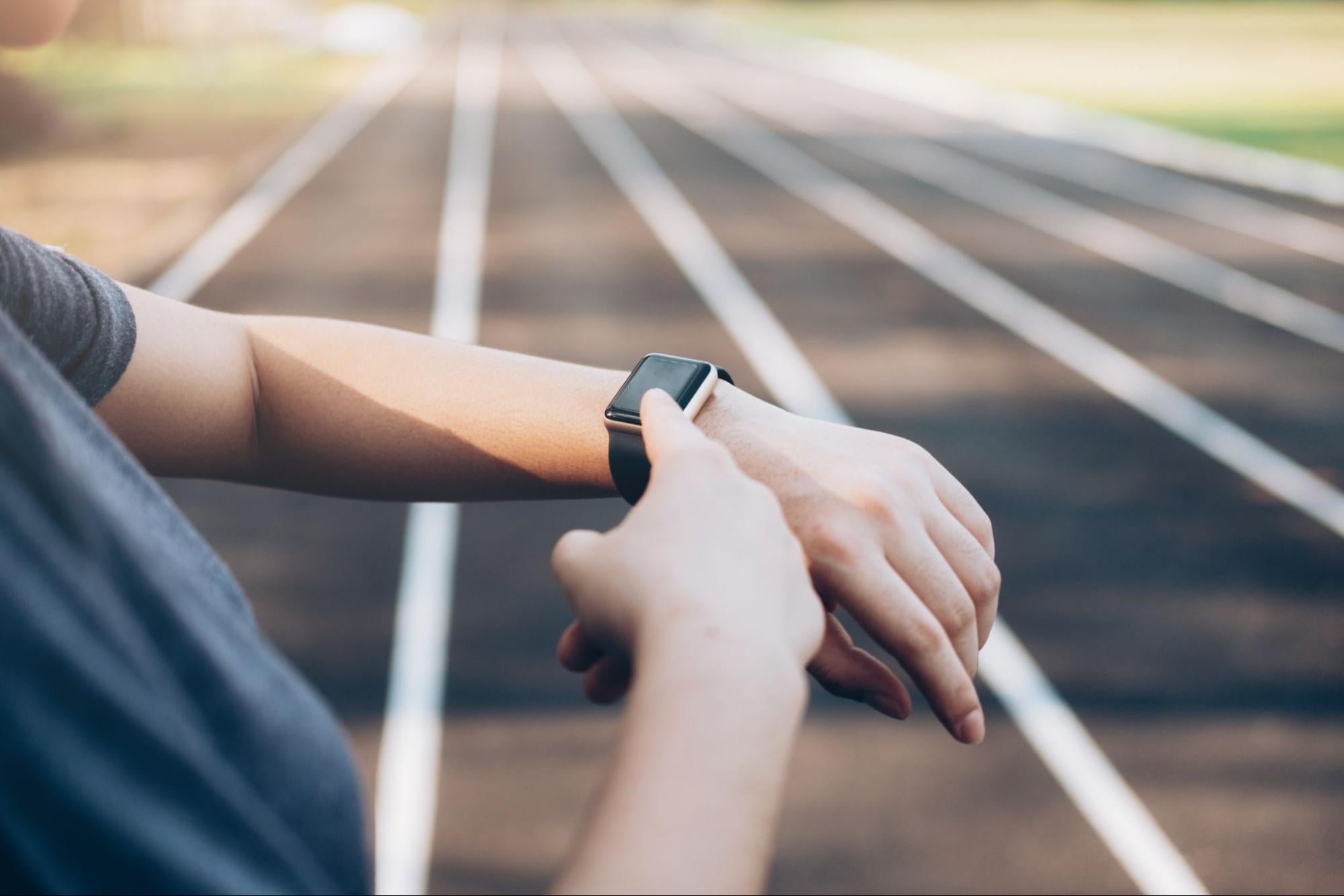 Athlete points at smart watch