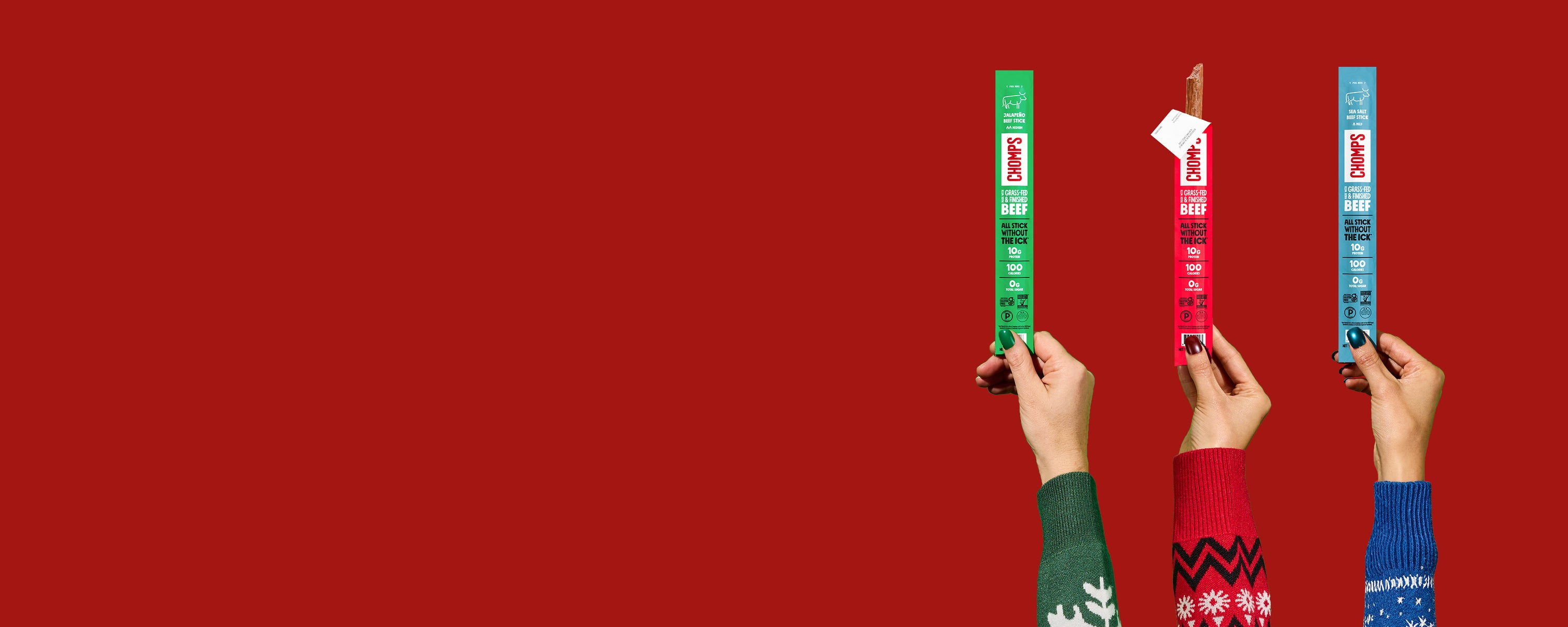 Three hands holding green, red, and blue striped items against a red background