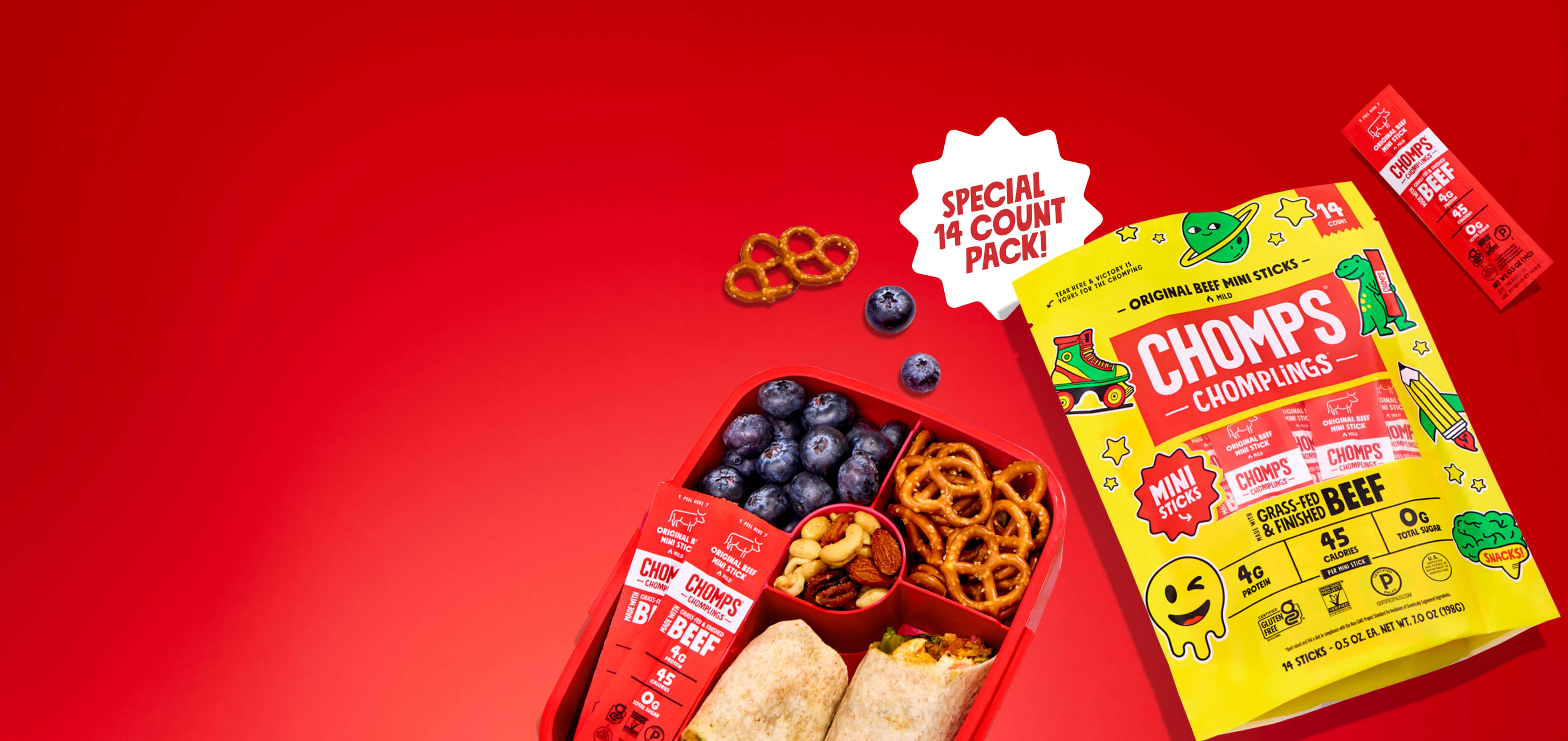 A red bento lunch box filled with blueberries, pretzels, and Chomps Chomplings. Showning a Chomplings 14ct pack. A white burst says 'SPECIAL 14 COUNT PACK!'.