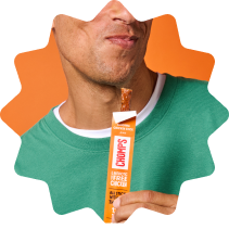 A close-up of a man's face and hand holding a Chomps Original Chicken stick. set against an orange background