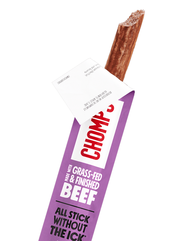 A single Chomps Taco seasoned beef stick snack partially pulled from its purple wrapper 