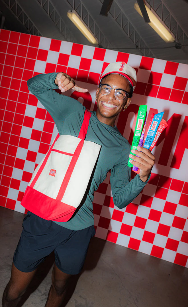 Person holding chomps sticks in front of a red and white checkered wall
